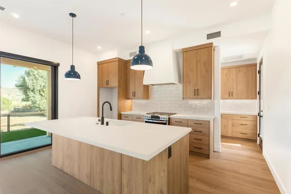 a kitchen with a sink a stove and a wooden floor