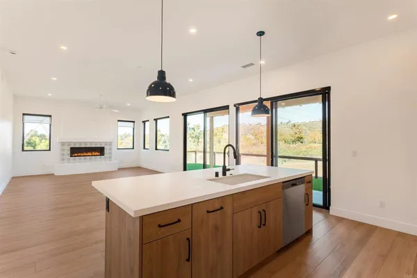 a kitchen with a sink a center island and a wooden floor