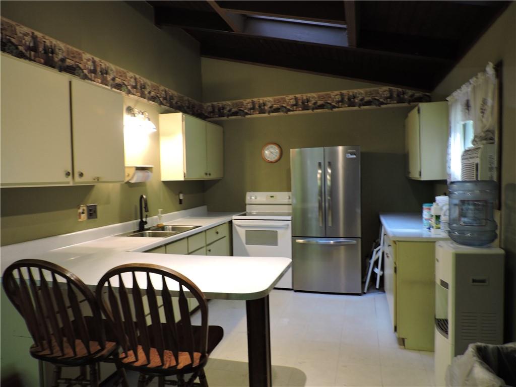 155 Maple Road Acme, PA 15610 - Photo 12 of 39 a kitchen with a table chairs refrigerator and cabinets