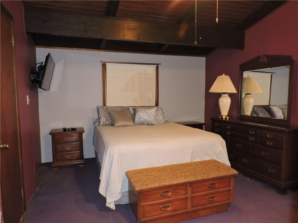 155 Maple Road Acme, PA 15610 - Photo 15 of 39 a bedroom with a bed and a dresser with mirror