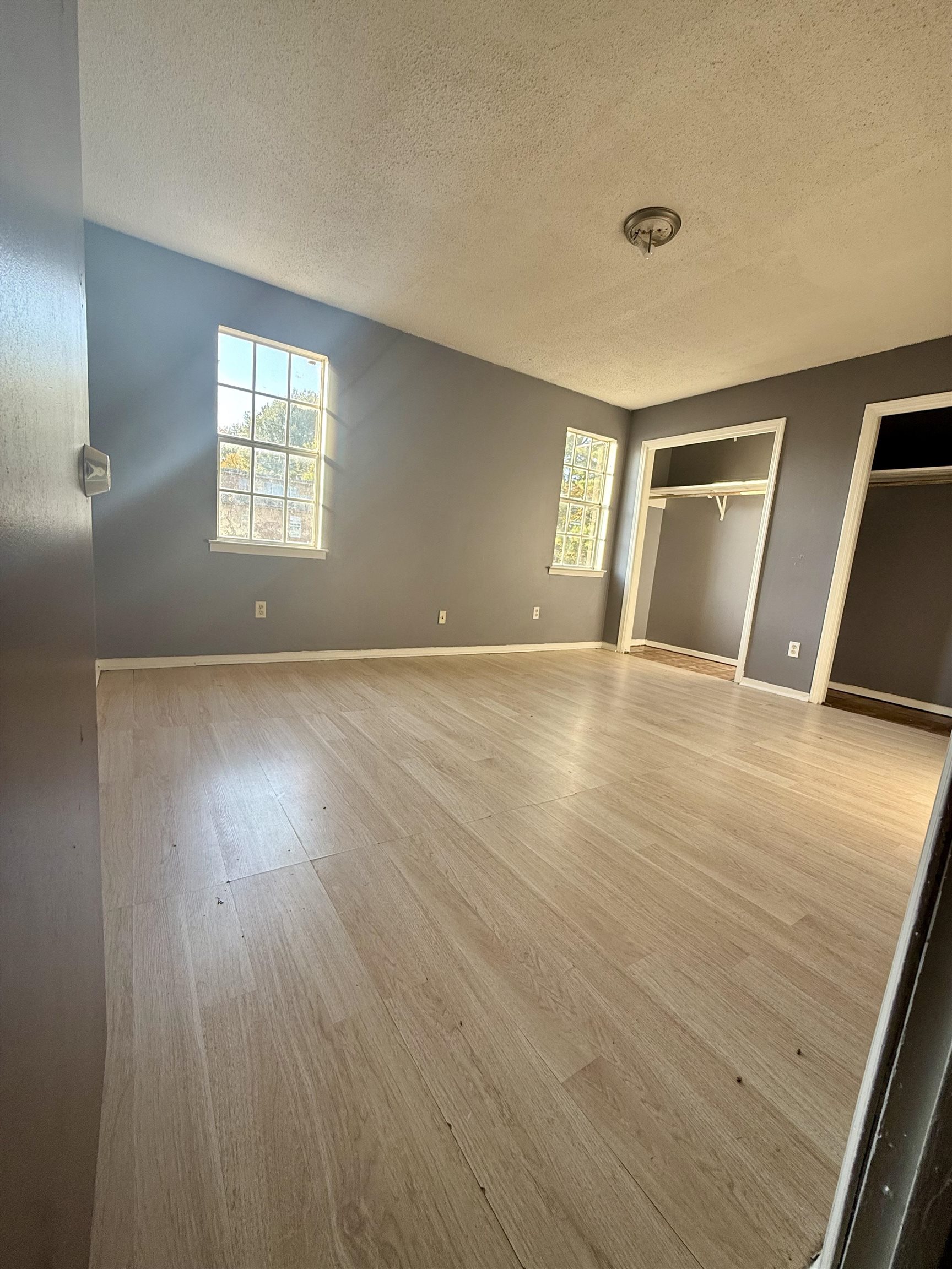 3091 Range Line Road Memphis, TN 38127 - Photo 8 of 13 Unfurnished bedroom with two closets, light wood-style floors, and a textured ceiling