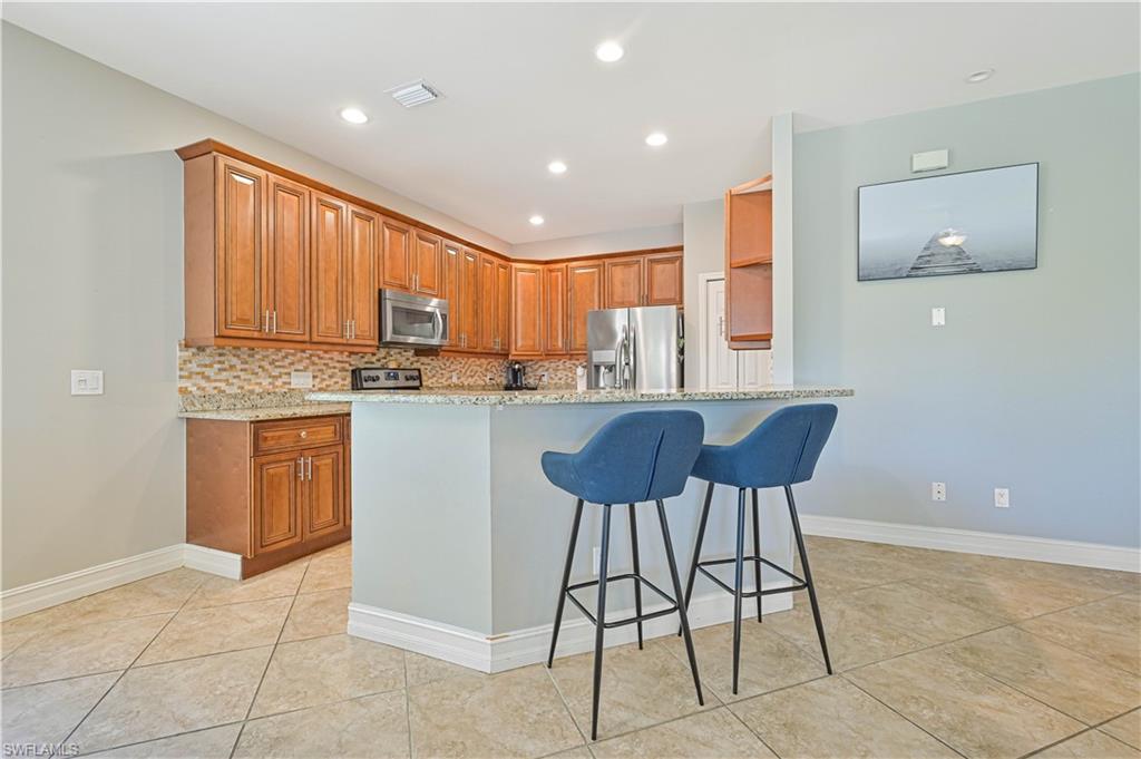238 Stanhope Circle Naples, FL 34104 - Photo 14 of 33 a kitchen with a stove a refrigerator and island cabinets