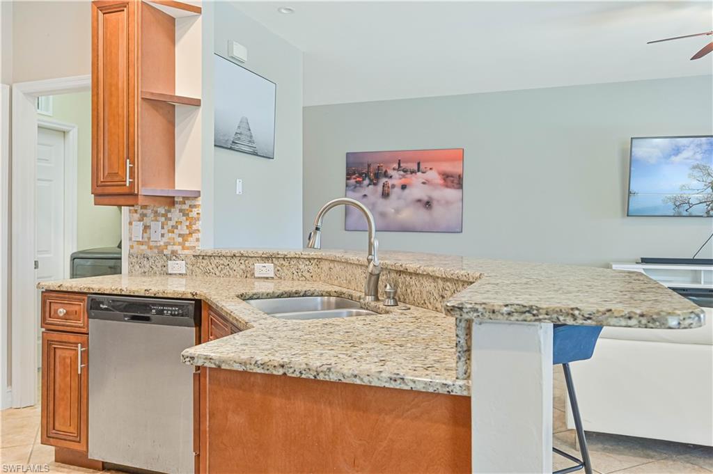 238 Stanhope Circle Naples, FL 34104 - Photo 16 of 33 a kitchen with stainless steel appliances granite countertop a sink and a stove