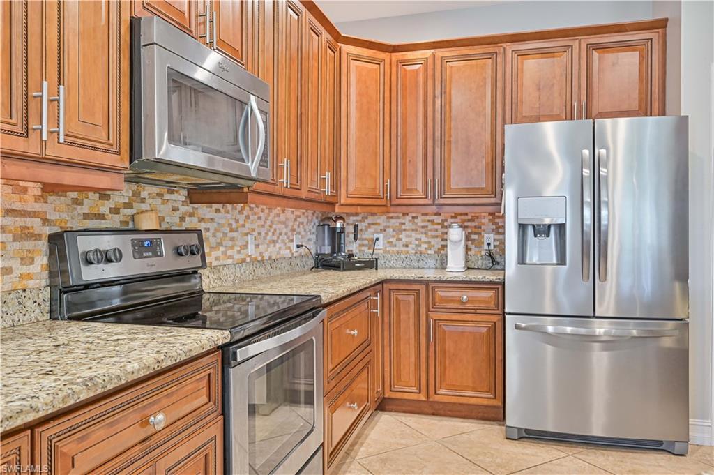 238 Stanhope Circle Naples, FL 34104 - Photo 17 of 33 a kitchen with granite countertop stainless steel appliances a refrigerator and cabinets
