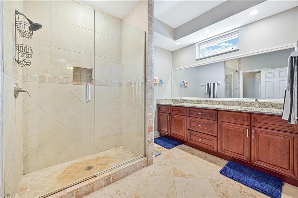 238 Stanhope Circle Naples, FL 34104 - Photo 25 of 33 a spacious bathroom with a granite countertop sink mirror and shower