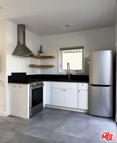 a kitchen with stainless steel appliances a refrigerator sink and white cabinets