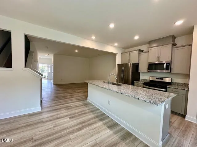 a large white kitchen with kitchen island a sink stainless steel appliances and cabinets