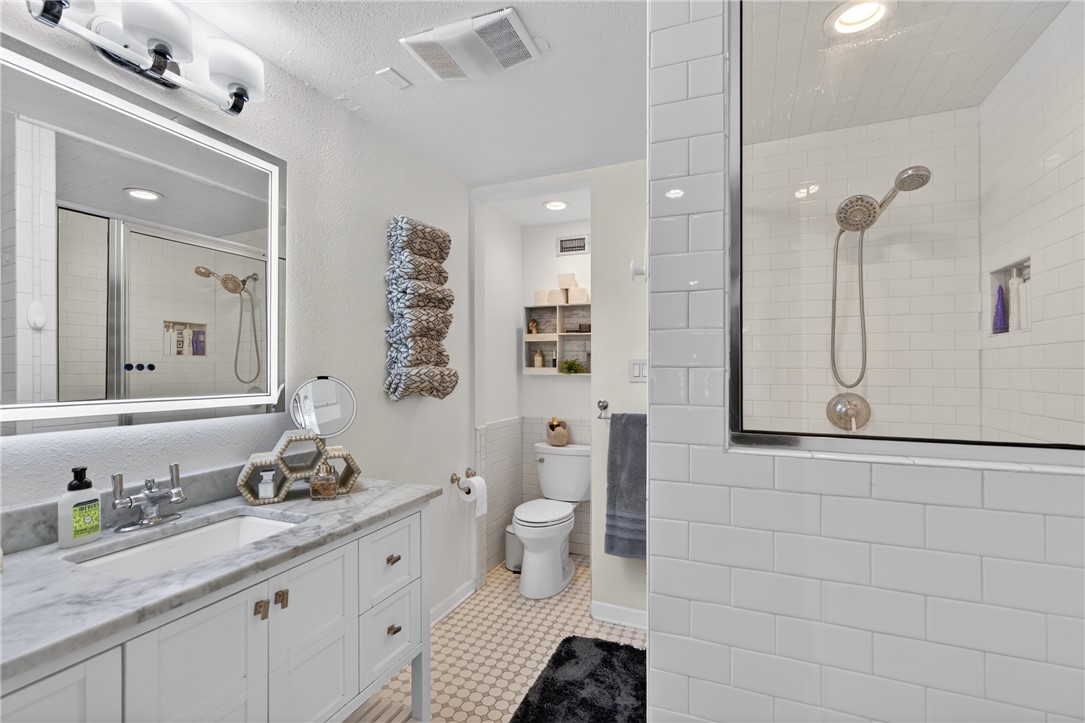 24937 County Road 350 Mathis, TX 78368 - Photo 19 of 39 a bathroom with a granite countertop sink a toilet a mirror and shower