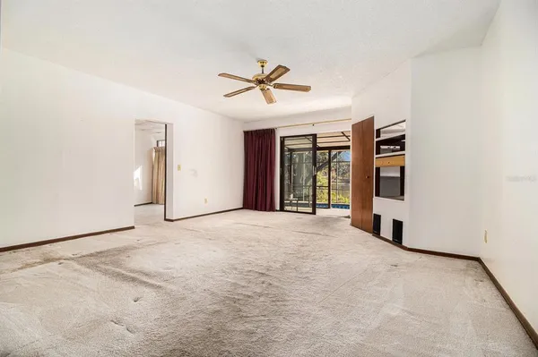 a view of a livingroom with a ceiling fan and window