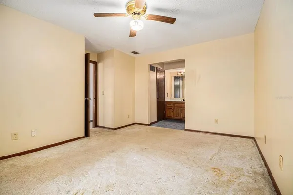 an empty room with closet and a chandelier fan