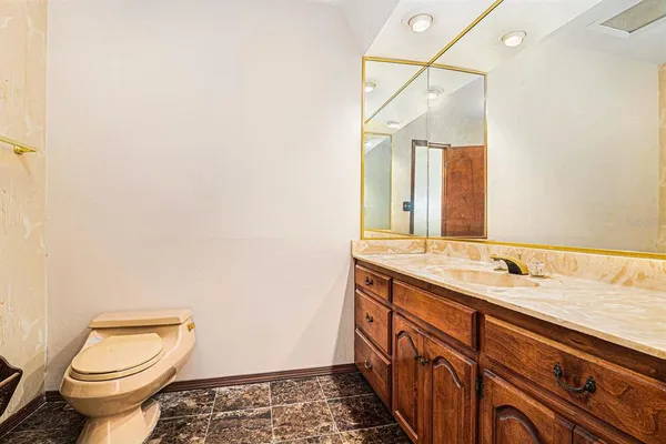 a bathroom with a granite countertop toilet sink and mirror