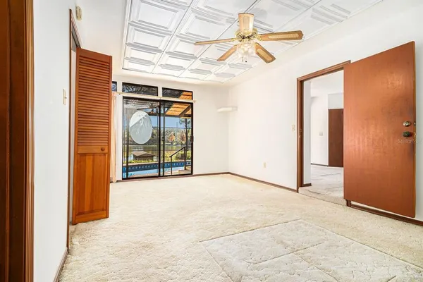 an empty room with windows and fan