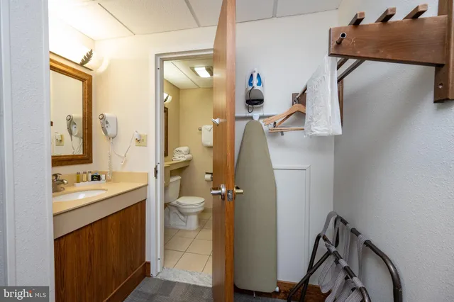 a bathroom with a sink and mirror with toilet