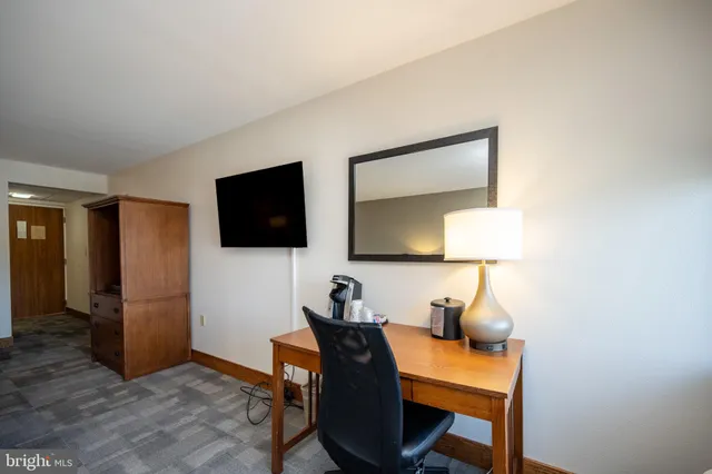 a view of a workspace with furniture and wooden floor