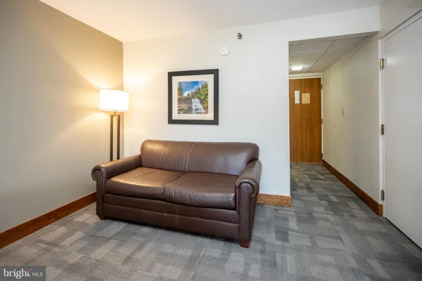 a living room with furniture and a lamp