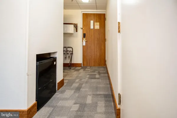 a view of hallway with a closet and wooden floor