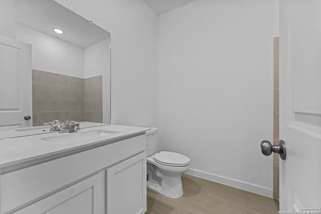 a bathroom with a granite countertop sink toilet and mirror