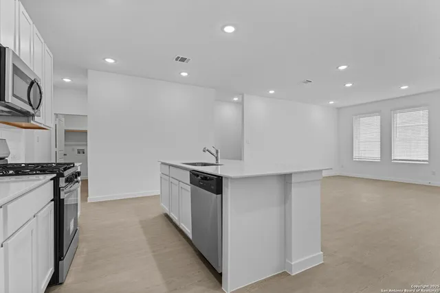 a kitchen with stainless steel appliances granite countertop a stove and a sink