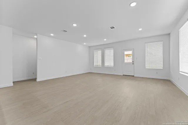 an empty room with windows and closet