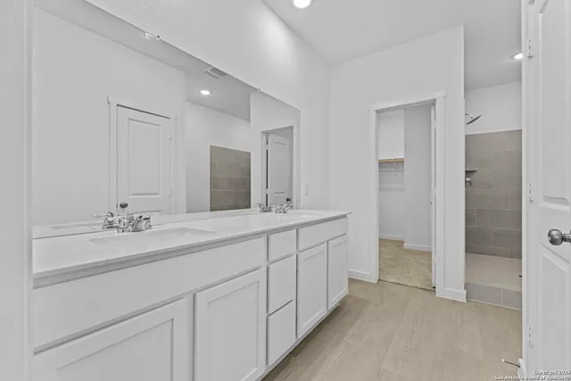 a bathroom with double sink and a mirror