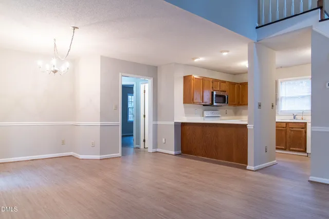 a view of a kitchen with a sink and dishwasher a kitchen island with wooden floor