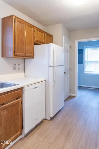 a utility room with wooden floor washer and dryer