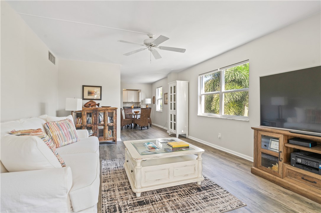 275 Date Palm Road, Unit 307 Vero Beach, FL 32963 - Photo 14 of 36 a living room with furniture a flat screen tv and a window