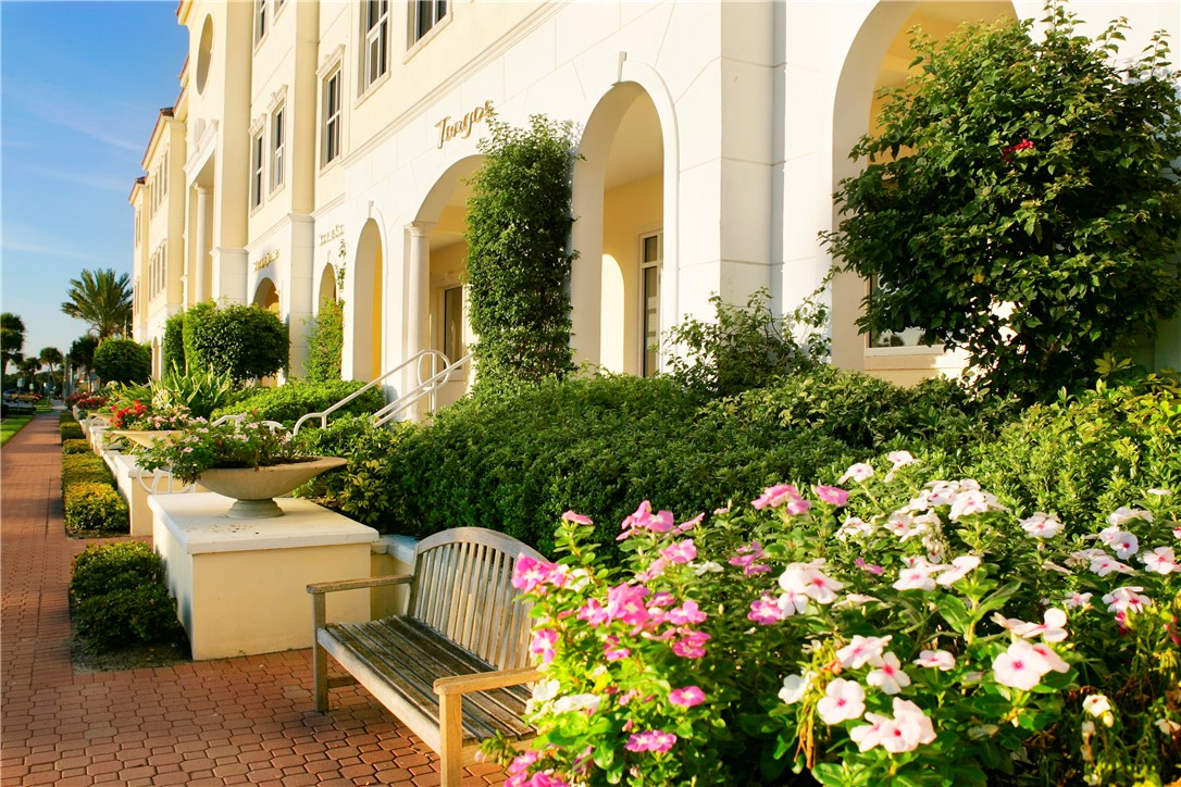275 Date Palm Road, Unit 307 Vero Beach, FL 32963 - Photo 33 of 36 a front view of a multi story residential apartment building with yard and flowers