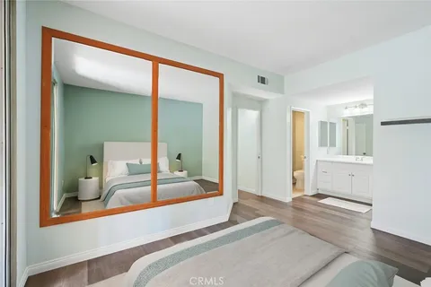 a bedroom with a bed and a large mirror