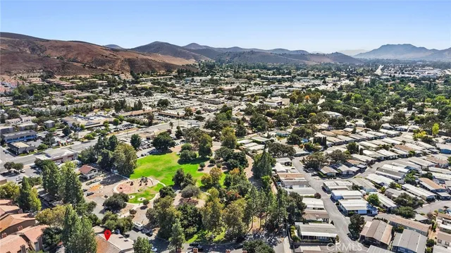 an aerial view of residential houses with outdoor space and trees