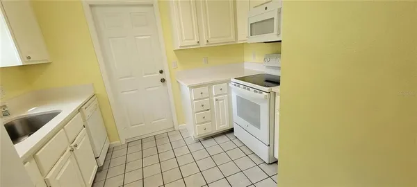 a kitchen with a sink a stove top oven and cabinets
