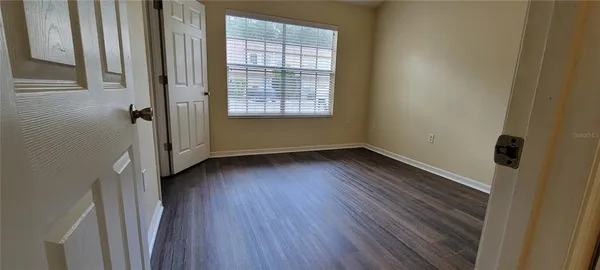 a view of a room with wooden floor and window