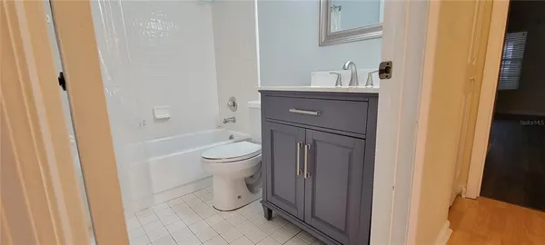 a bathroom with a granite countertop toilet and a sink