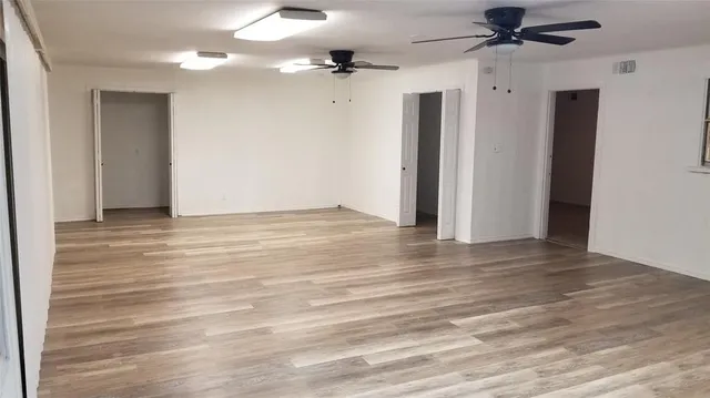 an empty room with wooden floor a ceiling fan and closet
