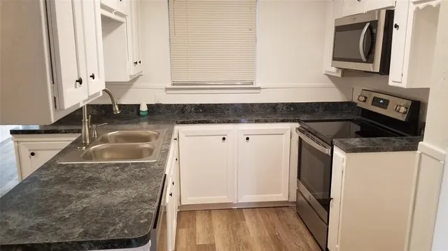 a kitchen with granite countertop a sink and a stove
