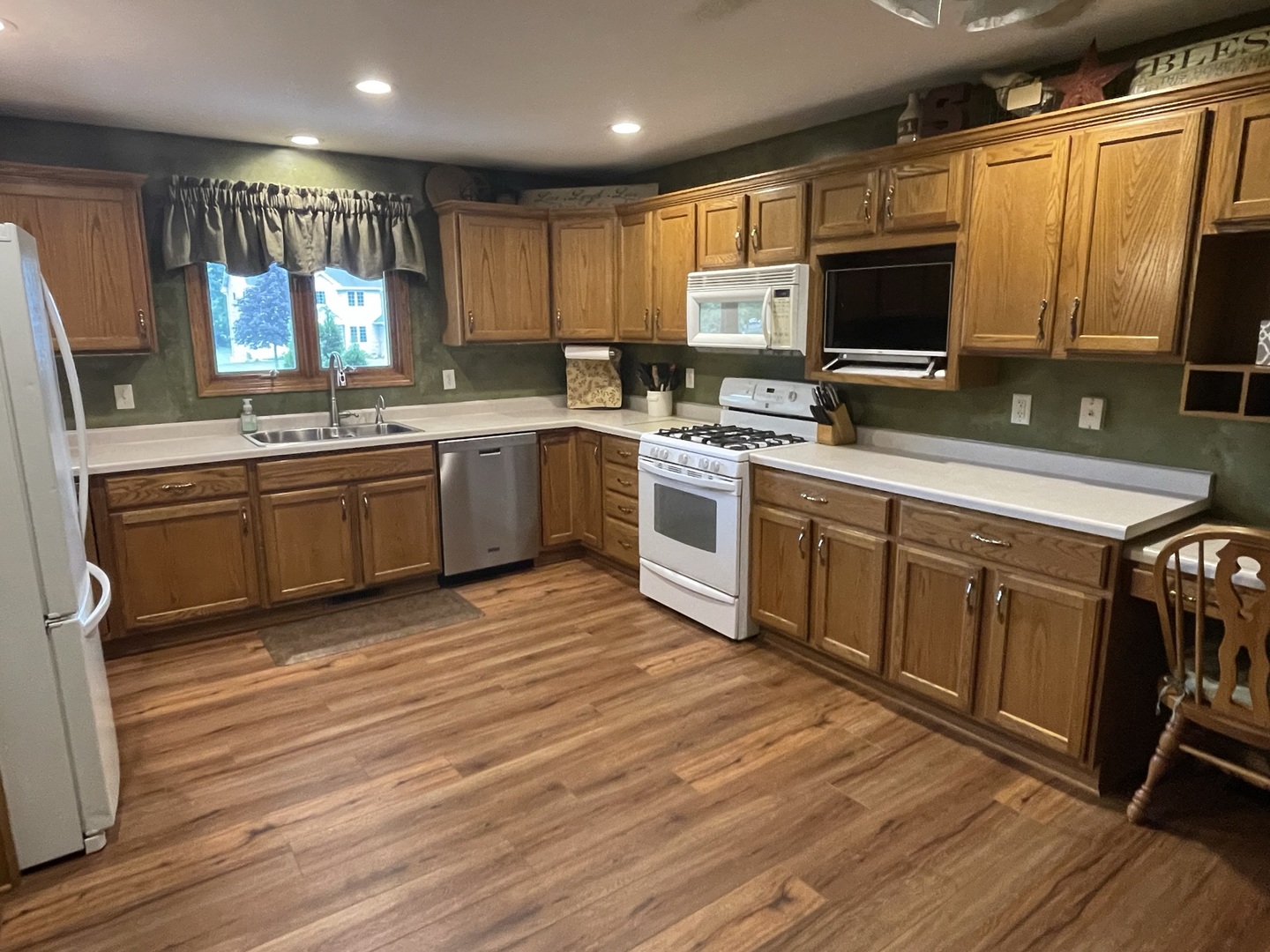 8701 South Rood Road Kingston, IL 60145 - Photo 6 of 26 a kitchen with stainless steel appliances granite countertop wooden cabinets a sink dishwasher a stove and a refrigerator with wooden floor