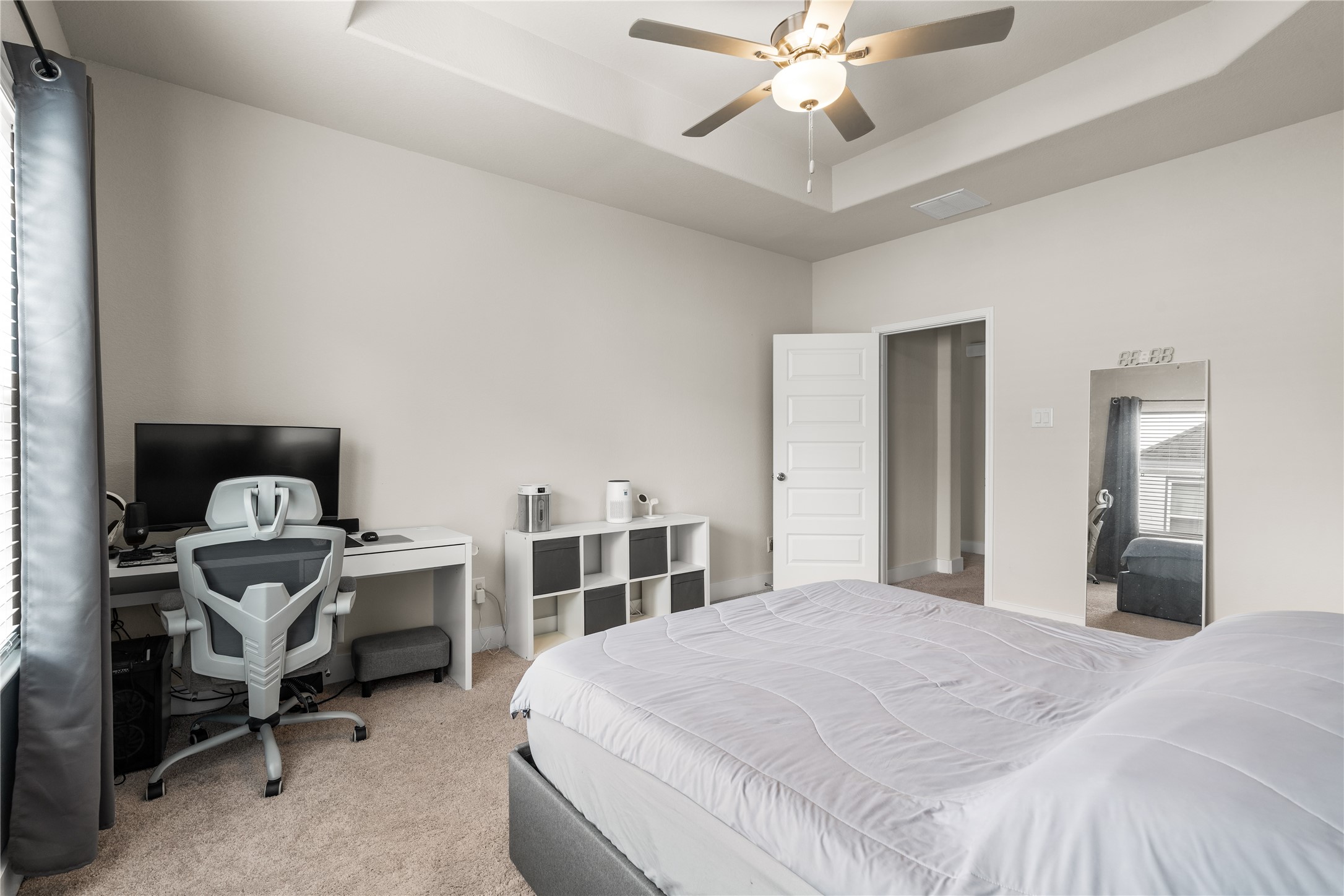 4001 Baja Lane Houston, TX 77045 - Photo 13 of 27 Elevated by a tray ceiling, the primary suite feels open and airy while offering ample space for both a sleeping area and a dedicated workspace or reading corner.