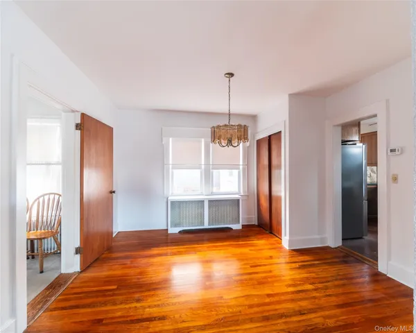 a view of empty room with wooden floor and window