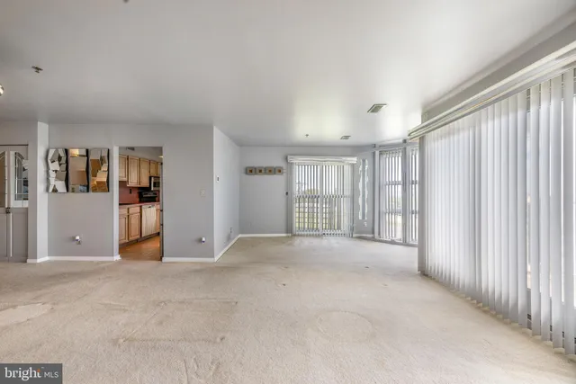 a kitchen with stainless steel appliances granite countertop a refrigerator a sink dishwasher a stove and a dining table with wooden floor