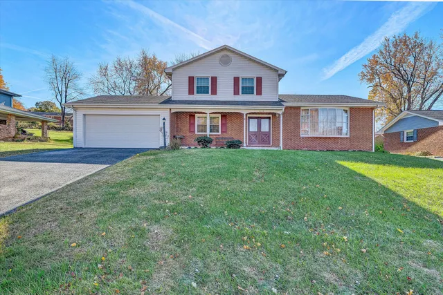 a view of a yard in front of a house with large tree