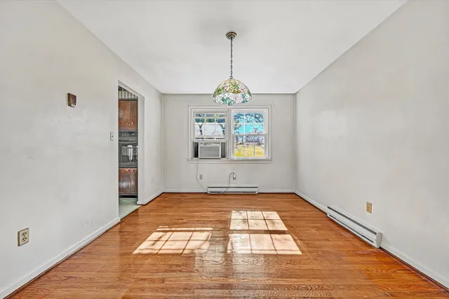a view of empty room with wooden floor