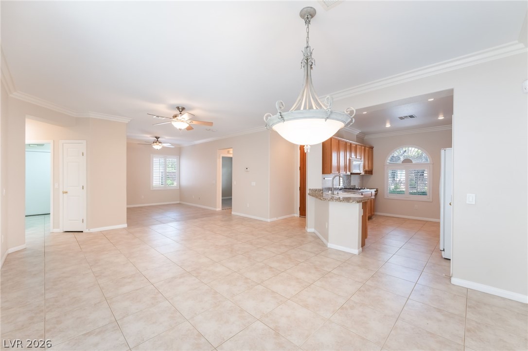 10481 Riverside Park Avenue Las Vegas, NV 89135 - Photo 51 of 51 Kitchen with ceiling fan, ornamental molding, open floor plan, wood finish cabinetry, and white appliances