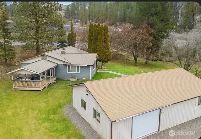 a aerial view of a house with swimming pool and large trees