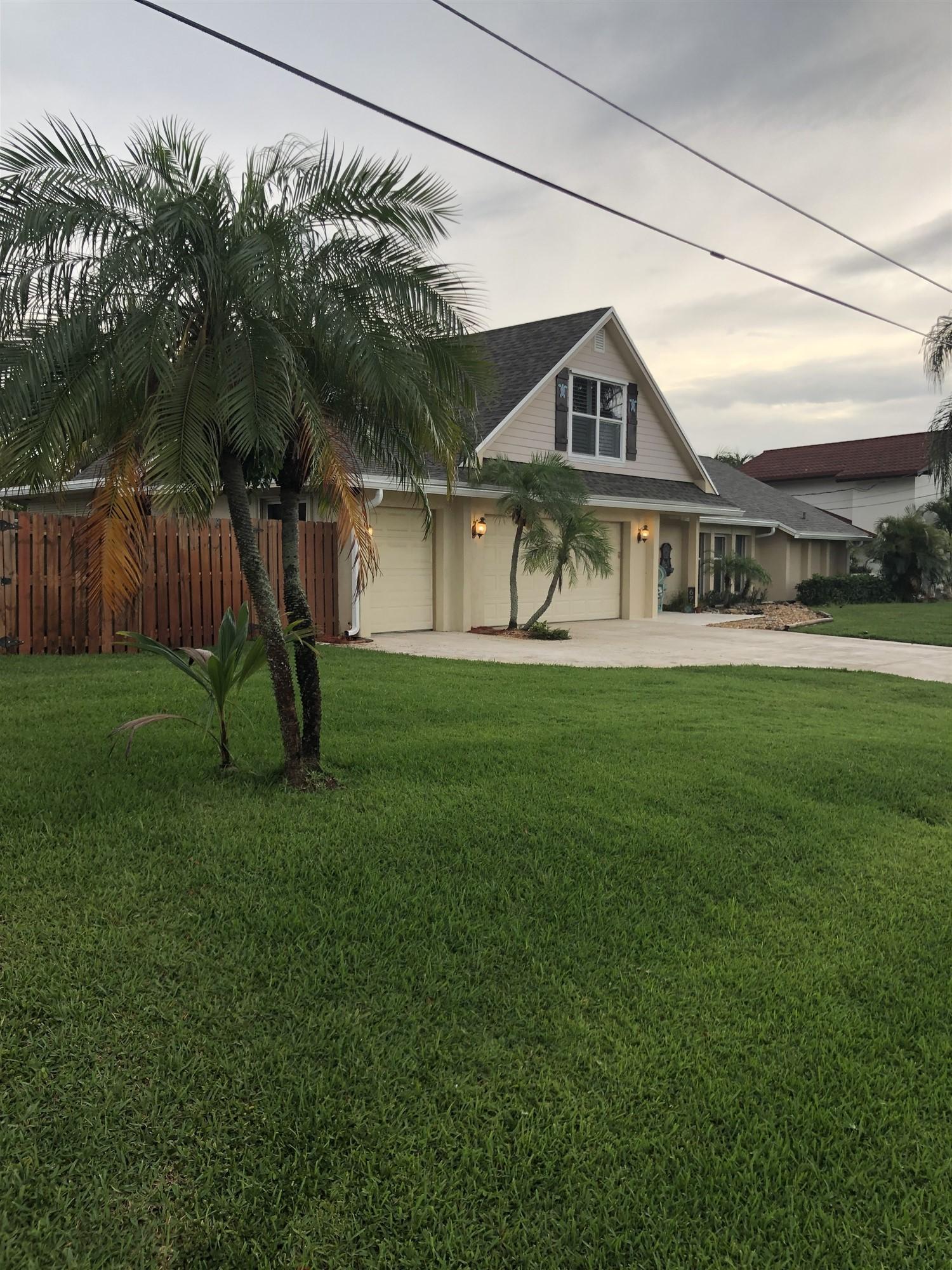 67 Fairview West Tequesta, FL 33469 - Photo 24 of 25 a view of a house next to a big yard and large trees