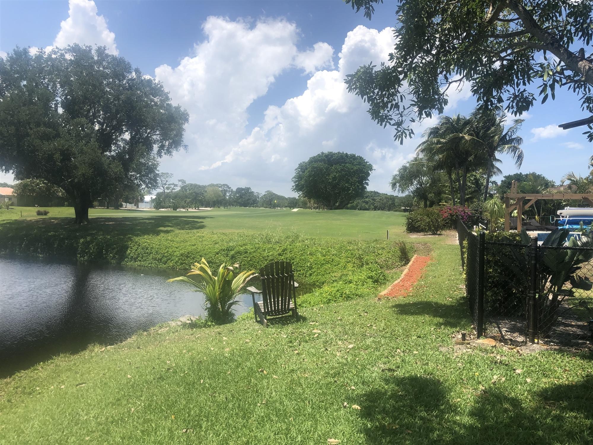 67 Fairview West Tequesta, FL 33469 - Photo 4 of 25 a view of a lake with a garden and fire pit