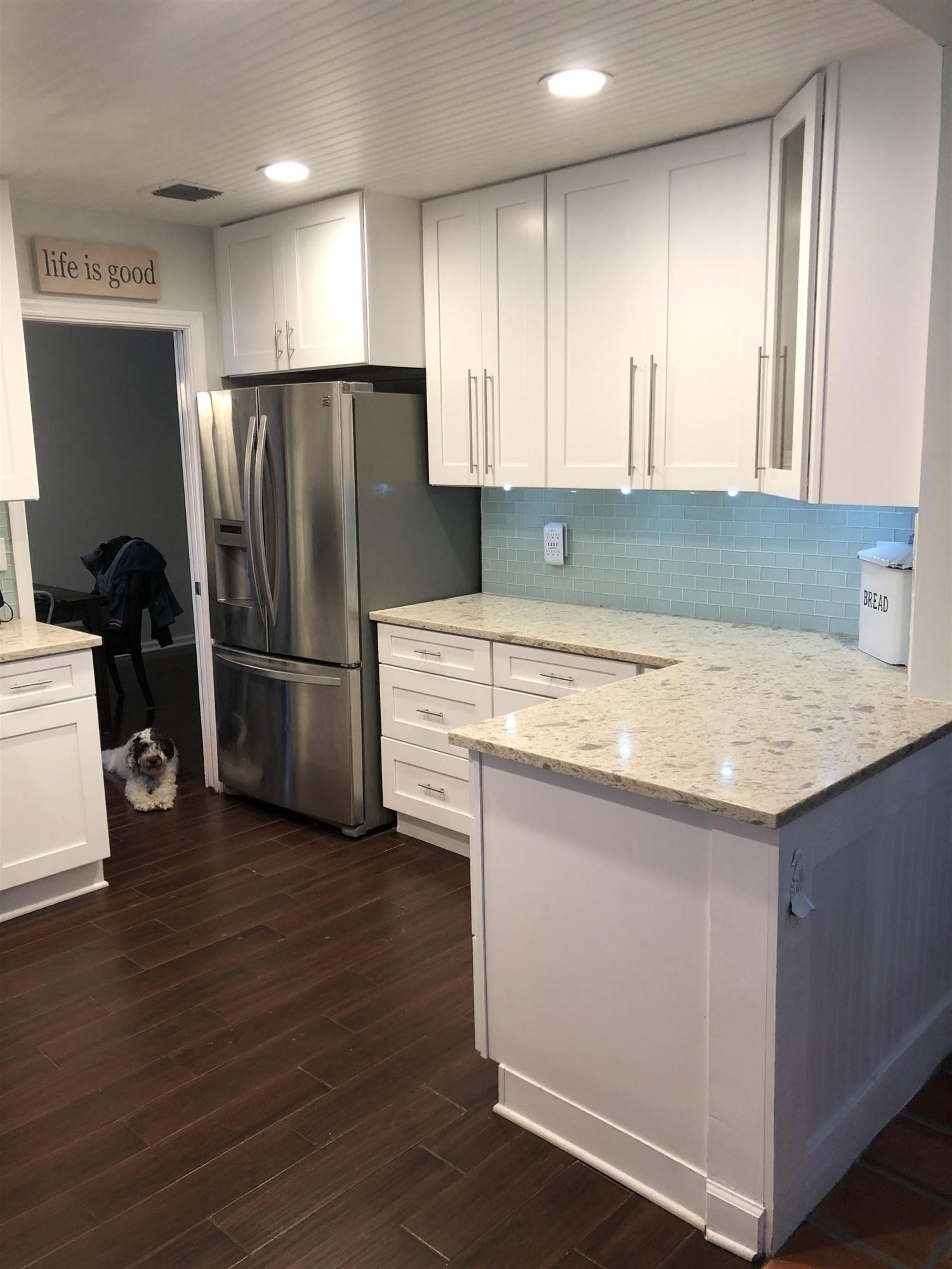 67 Fairview West Tequesta, FL 33469 - Photo 10 of 25 a kitchen with granite countertop a refrigerator and a stove top oven