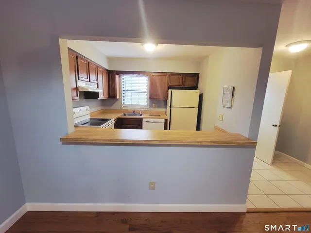 a view of living room with stainless steel appliances wooden floor and large window