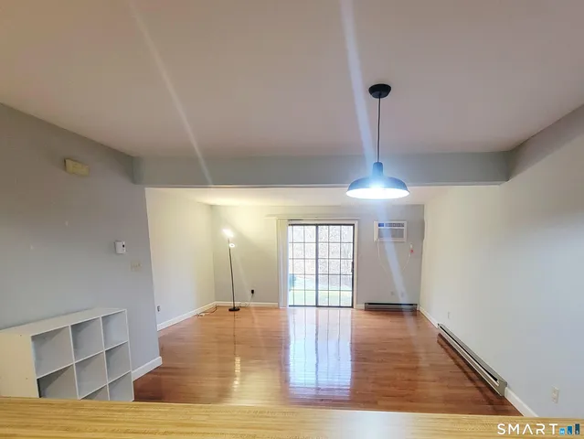 a view of empty room with wooden floor