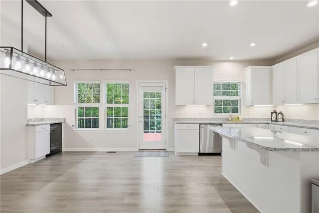 a large kitchen with stainless steel appliances granite countertop a sink stove and a refrigerator