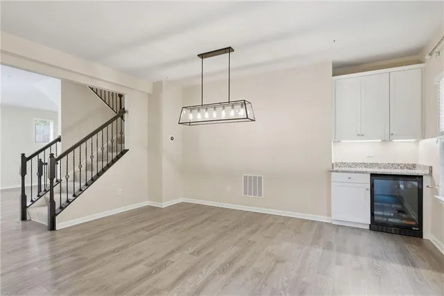 a view of an empty room with wooden floor fireplace and a window